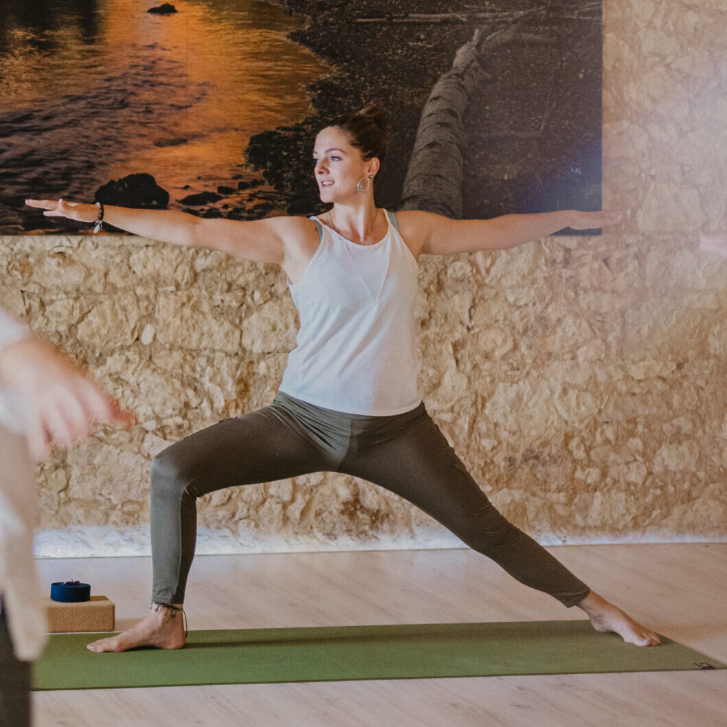 a woman doing a warrior yoga pose