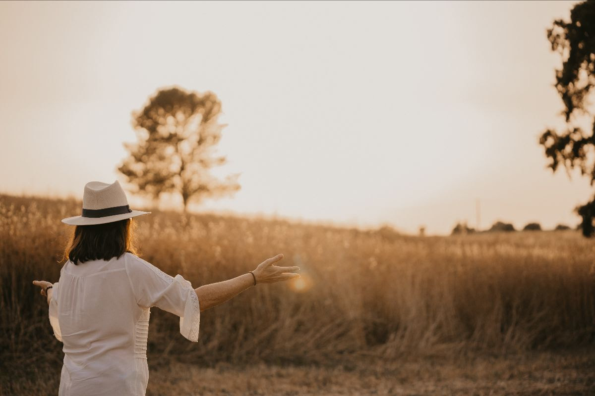 A woman raising her arms with nature background