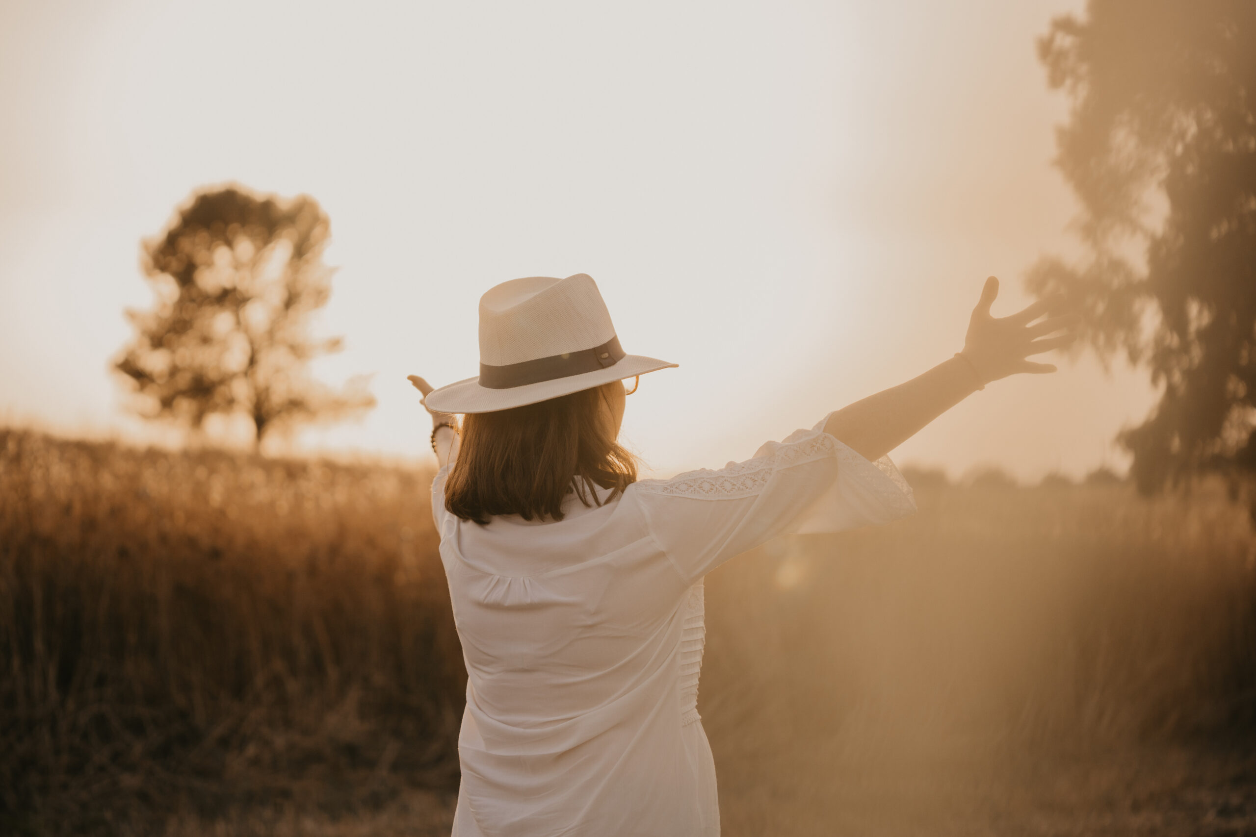 A woman raising her arms with nature background